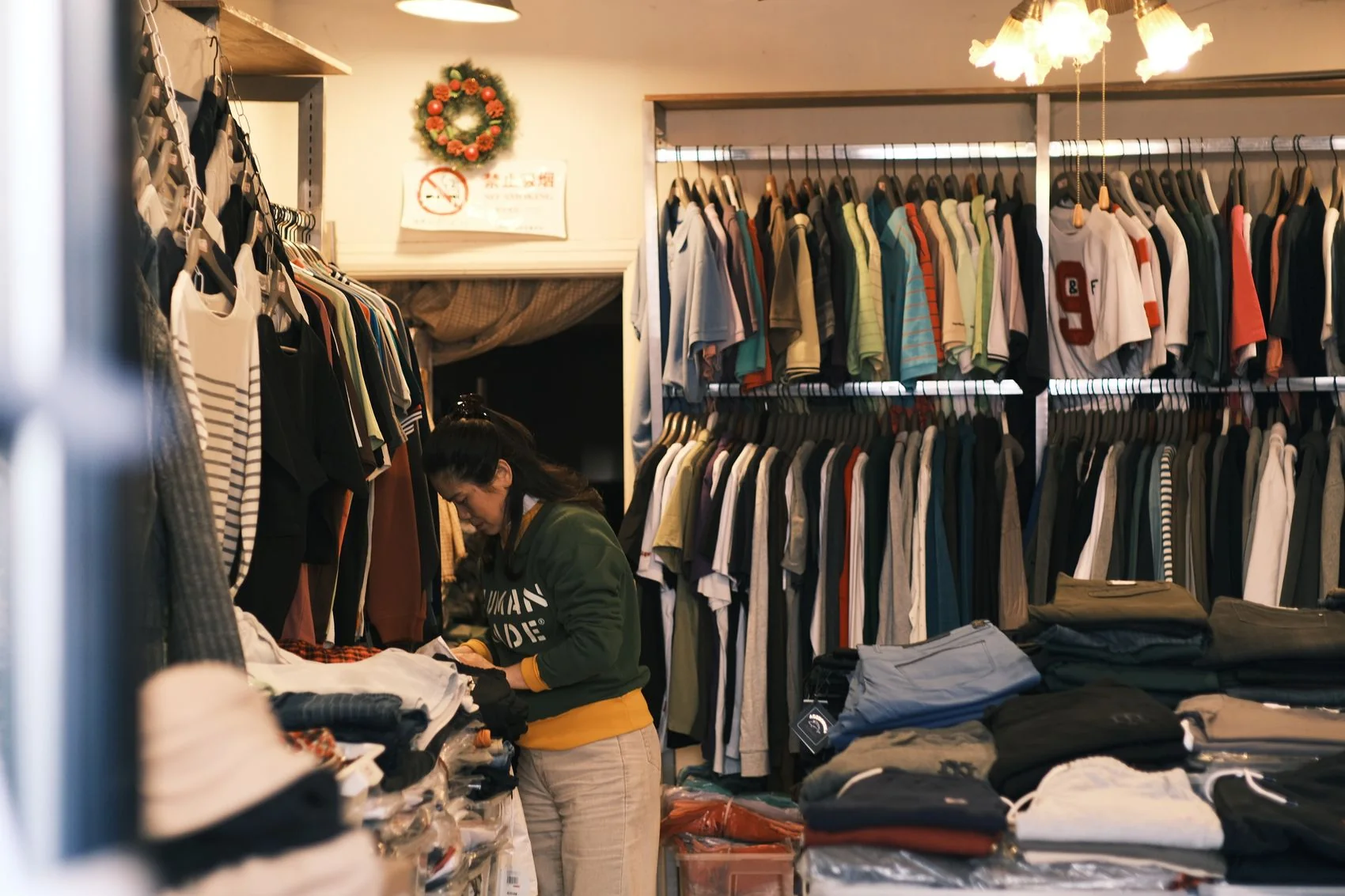 Une commerçante organise les vêtements dans sa boutique